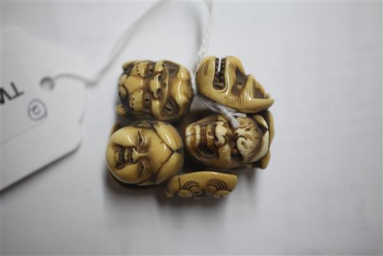 A Japanese ivory netsuke carved with nine Noh masks and another of a seated man asleep, both signed (2)